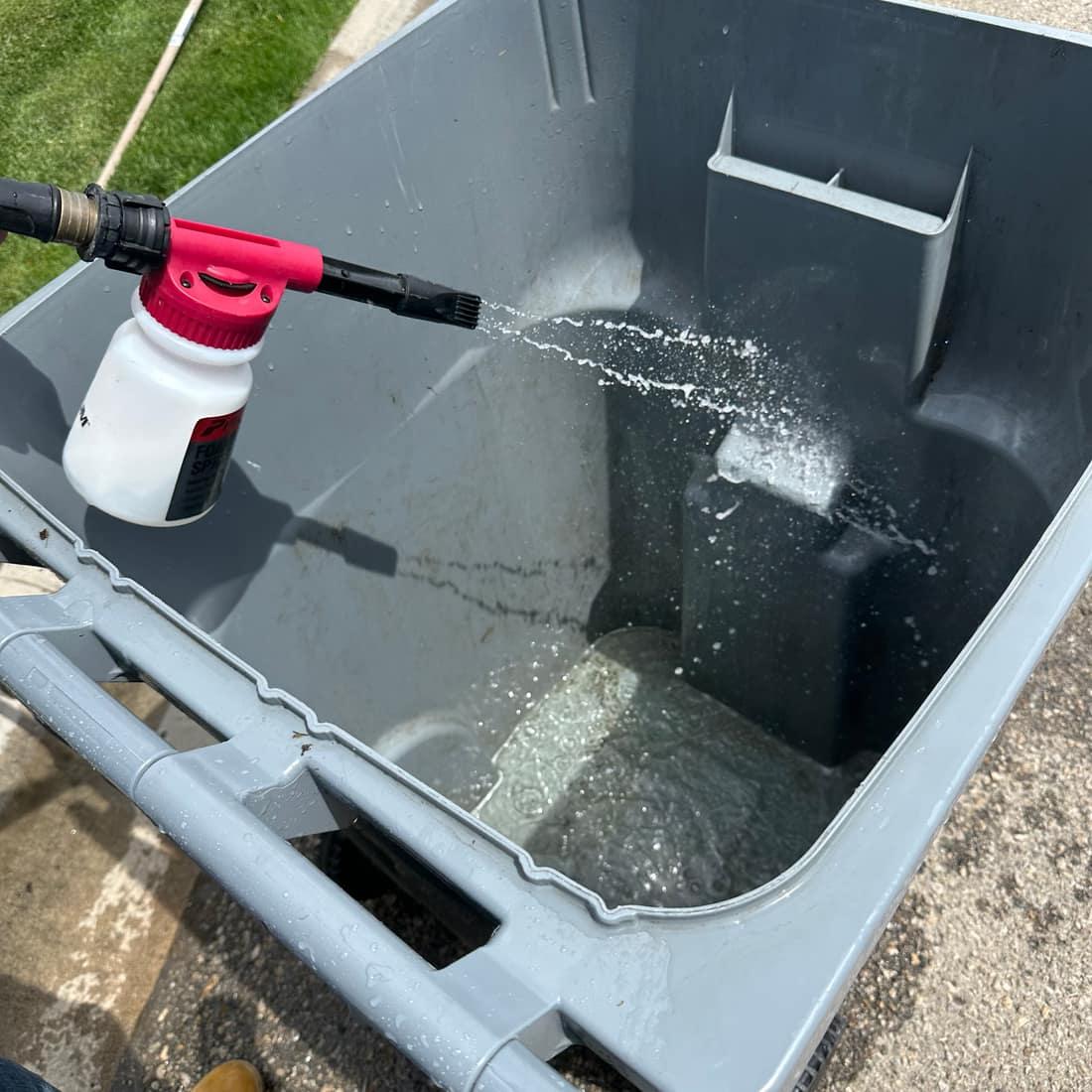 Close-up of water spraying inside a trash bin during cleaning